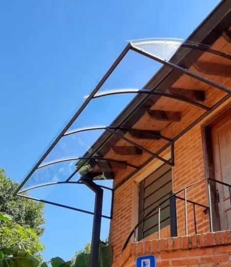 Marquesina curva para entrada de casa con estructura metálica